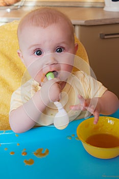 The baby of 7-8 months himself holds the spoon