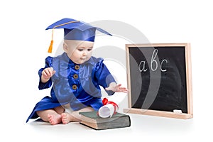 Baby in academician clothes with book at blackboard