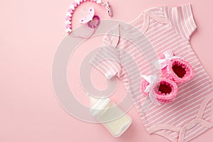 Baby accessories concept. Top view photo of pink bodysuit knitted booties pacifier chain and bottle on isolated pastel pink