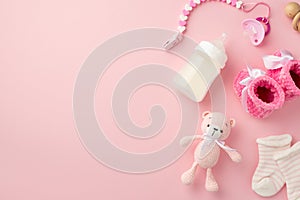 Baby accessories concept. Top view photo of pink booties socks knitted teddy-bear toy pacifier chain wooden rattle and bottle on