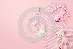 Baby accessories concept. Top view photo of pink infant clothes shirt shorts pacifier chain bottle shaped teether and knitted