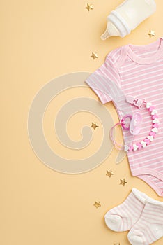 Baby accessories concept. Top view vertical photo of infant clothes pink bodysuit tiny socks bottle pacifier chain and gold stars