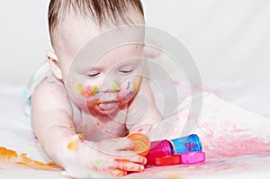 Baby age of 4 months with paper and finger-type paints