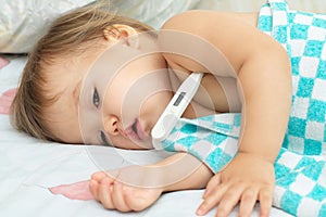 Baby ailing and lying with thermometer