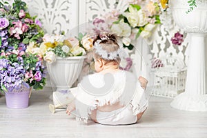 Baby with angel wings among flowers, valentine`s day concept, rear view