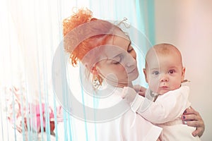 Baby in the arms of the girl. Mom holds her child in her arms. H