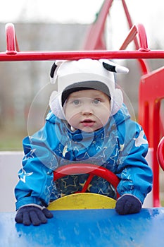 Baby in baby car on playgroud outdoors photo