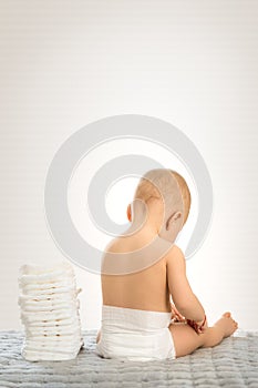 Baby from back sitting on white