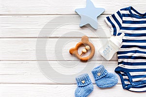 Baby background - blue color. Clothes and accessories for newborn boy on white wooden table top-down frame copy space