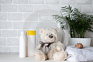 Baby bath accessories, towel, teddy bear and shampoo bottles. The concept of child care