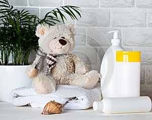 Baby bath accessories, towel, teddy bear and shampoo bottles. The concept of child care