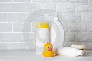 Baby bath accessories, towel, yellow rubber duck and shampoo bottles. The concept of child care