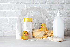 Baby bath accessories, towel, yellow rubber duck and shampoo bottles. The concept of child care