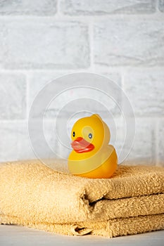 Baby bath accessories, towel, yellow rubber duck and shampoo bottles. The concept of child care