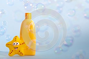 Baby bath foam or liquid soap with yellow star fish and many flying soap bubbles. Children's bath time concept. Copy