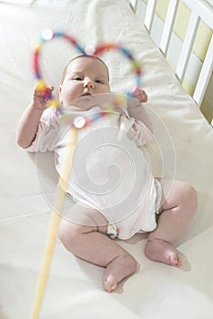 Baby in a bed in frame of heart shape.