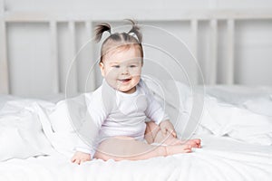 Baby on the bed at home smiling, the concept of a happy loving family and children