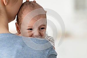 Baby Behavior. Closeup Portrait Of Young Mother Comforting Her Crying Infant Child