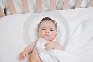 Baby with blanket in crib