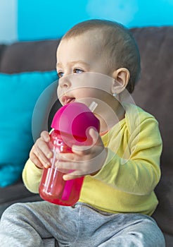 Baby with blue eyes holding bottle