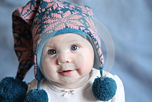Baby with blue eyes in a winter cap