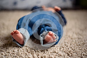 Baby in Blue Jeans Lying on the Carpet