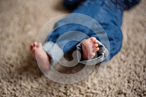 Baby in Blue Jeans Lying on the Floor