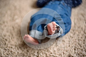 Baby in Blue Jeans Lying on the Floor