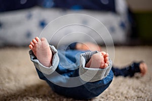 Baby in Blue Jeans Lying on the Floor