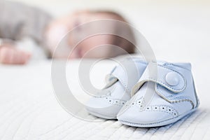 Baby blue shoes and babe sleeping on background