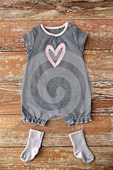 Baby bodysuit and socks on wooden table