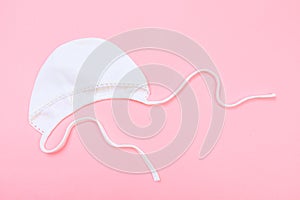 Baby bonnet on pastel pink background