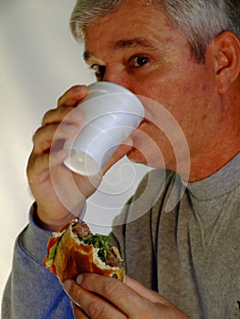 Baby Boomer Man eating hamburger