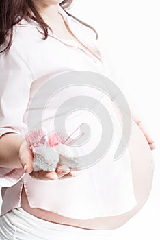Baby bootees in hand of pregnant woman