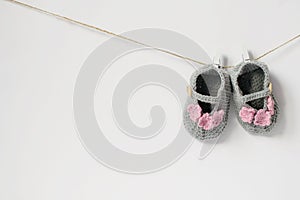 Baby booties for a little girl gray with pink flowers. Booties are crocheted. White background
