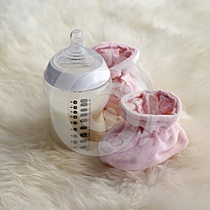 Baby bottle and bootee. Conceptual image