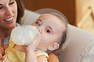 Baby, bottle and drinking milk, portrait and mom for meal, feeding and kid. Family time, eating and smile for nutrition