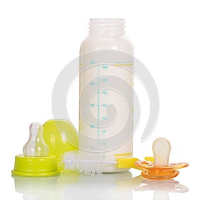 Baby bottle with milk, cleaning brush and pacifier isolated.