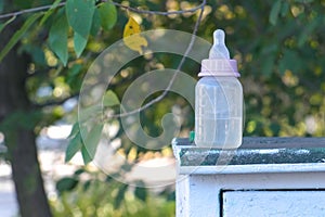 Baby bottle with pacifier in park. Kidnaping concept.