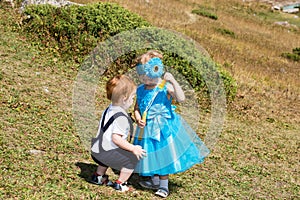 Baby boy and adorable child girl on grass. Summer green nature background