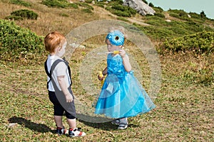 Baby boy and adorable child girl on grass. Summer green nature background.