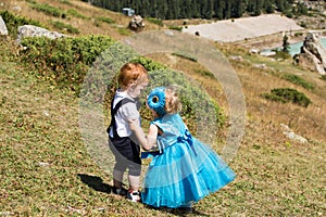 Baby boy and adorable child girl kissing on grass. Summer green nature .