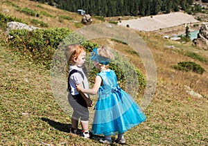Baby boy and adorable child girl playing on grass