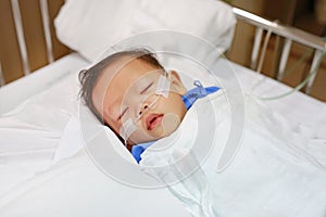 Baby boy age about 1 year old sleeping on patient bed with getting oxygen via nasal prongs to assure oxygen saturation. Intensive
