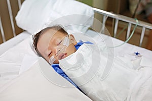 Baby boy age about 1 year old sleeping on patient bed with getting oxygen via nasal prongs to assure oxygen saturation. Intensive photo