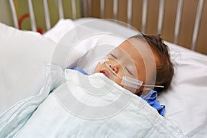 Baby boy age about 1 year old sleeping on patient bed with getting oxygen via nasal prongs to assure oxygen saturation. Intensive photo