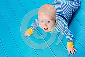 Baby boy on blue knitted blanket