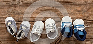 Baby boy blue shoes variety on wooden background, top view