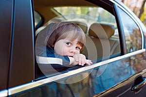 Baby boy in the car behind the wheel.