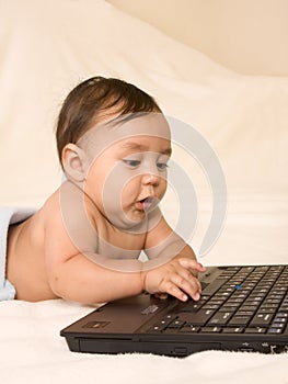 Baby boy checking e-mail on his parents laptop